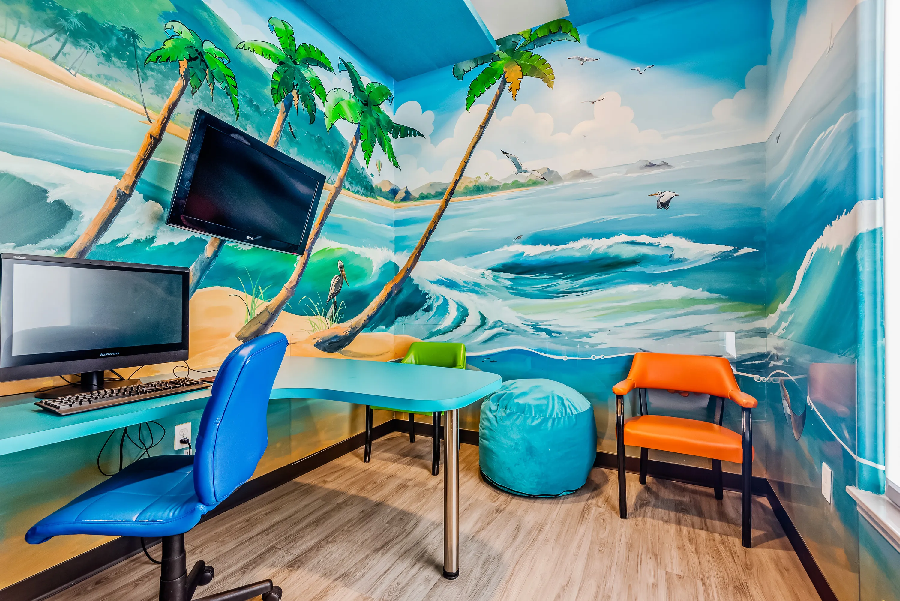 The Super Smiles consultation room, painted with a calm beach and palm tree mural